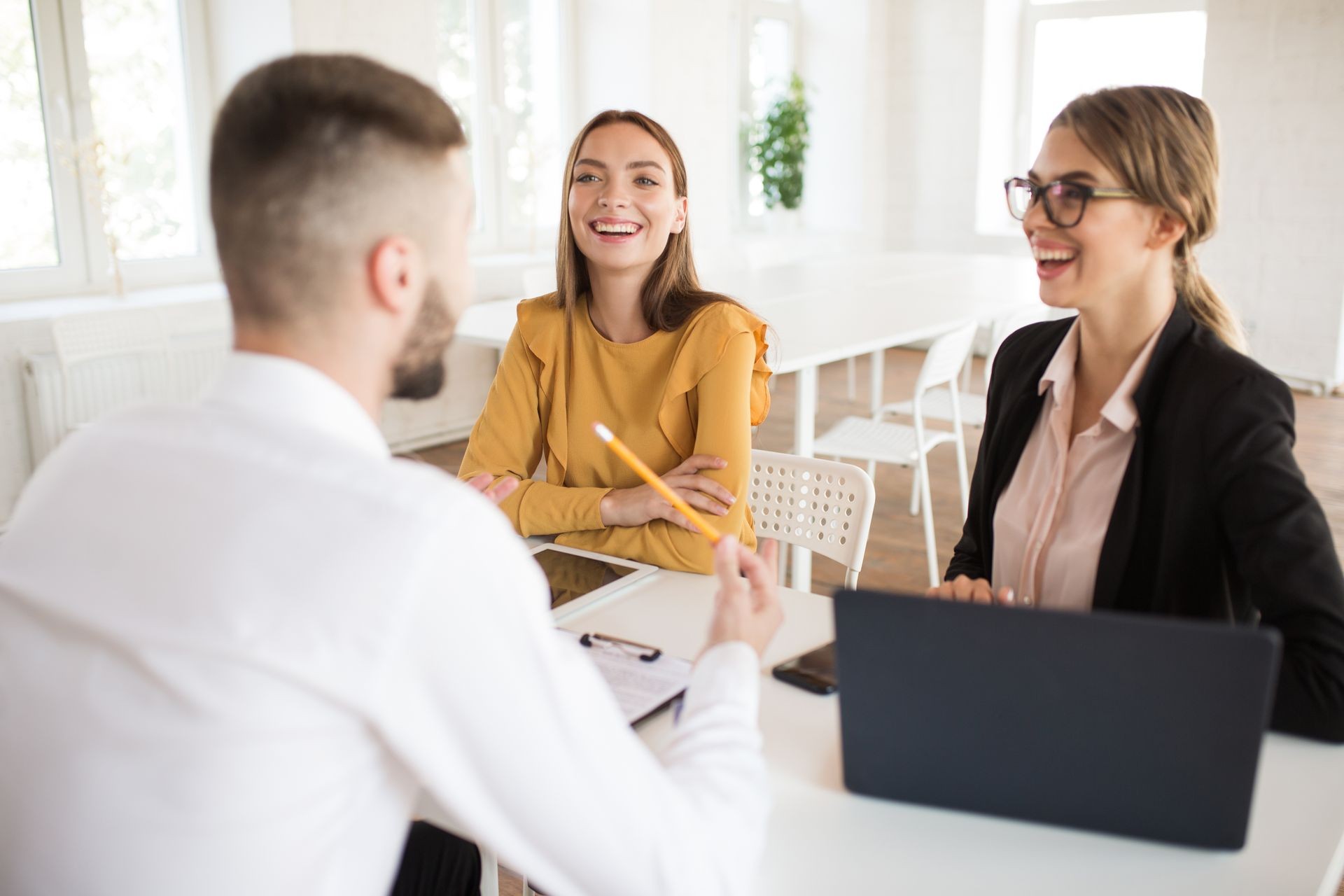 2 business women enjoy the interview with a candidate who prepared it with his career coach